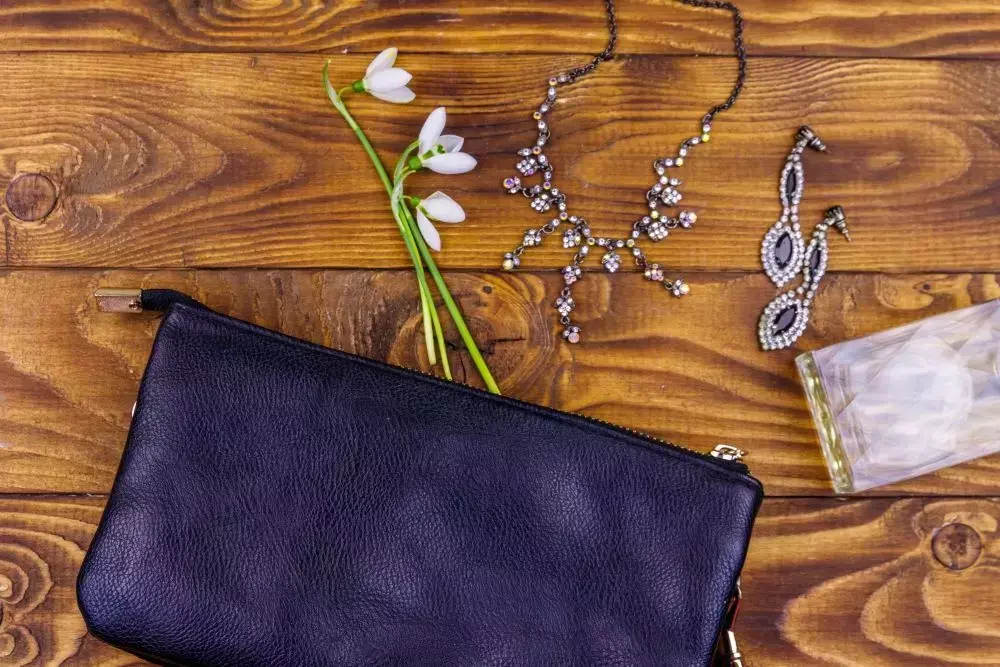 Túi clutch da màu tím navy handmade hoàn thiện trên nền gỗ với phụ kiện trang trí - hướng dẫn may túi clutch mùa hè